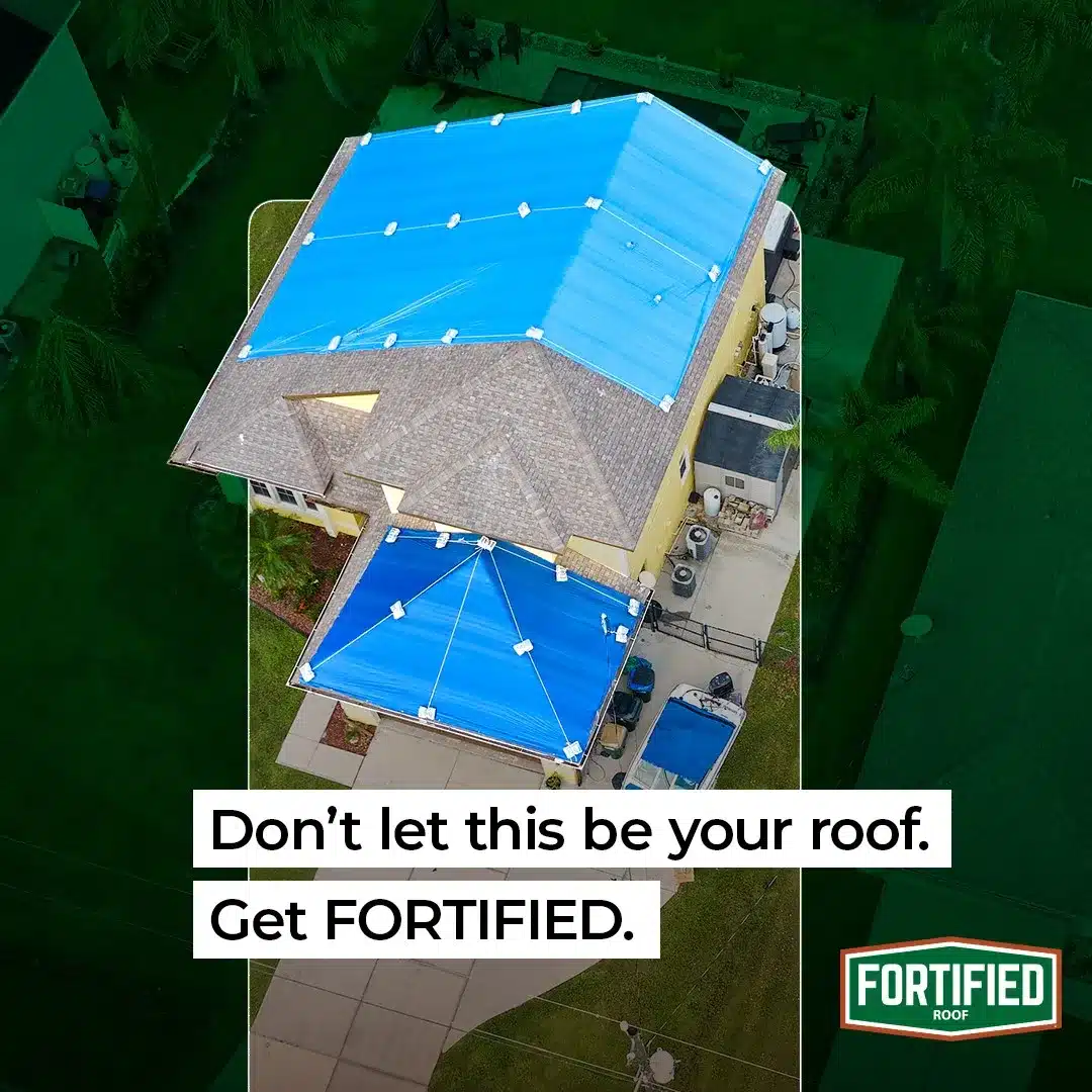 Aerial view of a house with blue tarps covering parts of its roof. The text on the image reads "Don't let this be your roof. Get FORTIFIED." The Fortified Roof logo is displayed at the bottom right. The house, surrounded by green lawns and other homes, shows the importance of roofing to prevent damage.