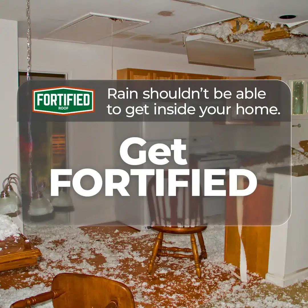 Kitchen with significant water damage and a collapsed ceiling, littered with debris and insulation. A sign with the text "FORITIFIED Roof" by Halo Roofing states, "Rain shouldn't be able to get inside your home. Get FORTIFIED.